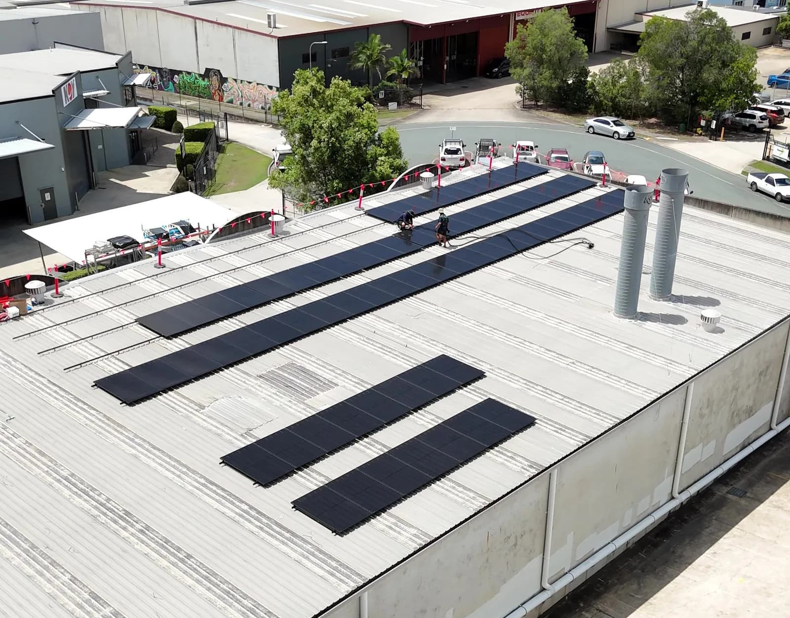 EFS Solar installers fitting a rooftop commercial solar array on an industrial building