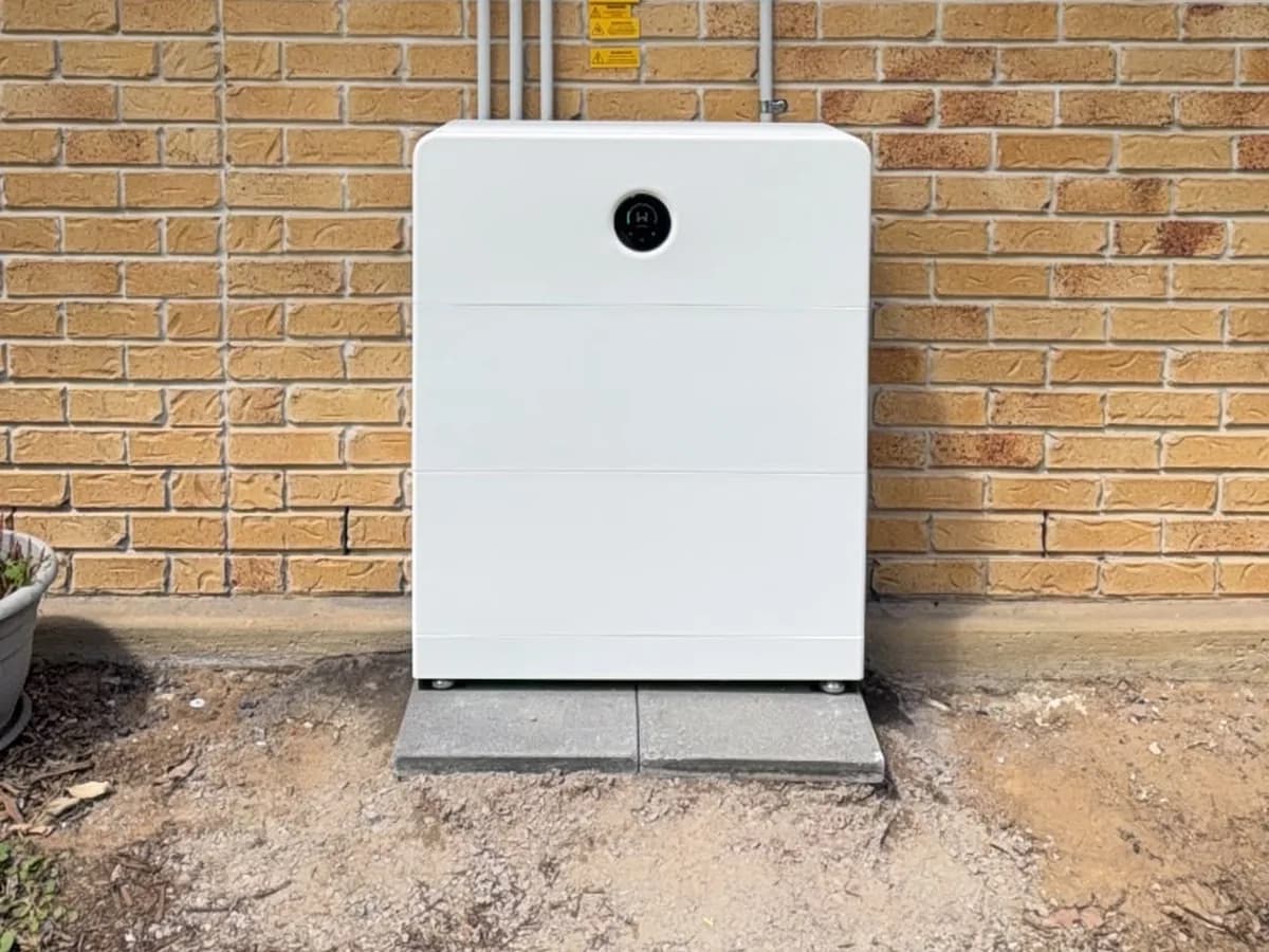 A home battery installed by EFS Solar against a yellow brick wall in Beerwah, standing on pavers