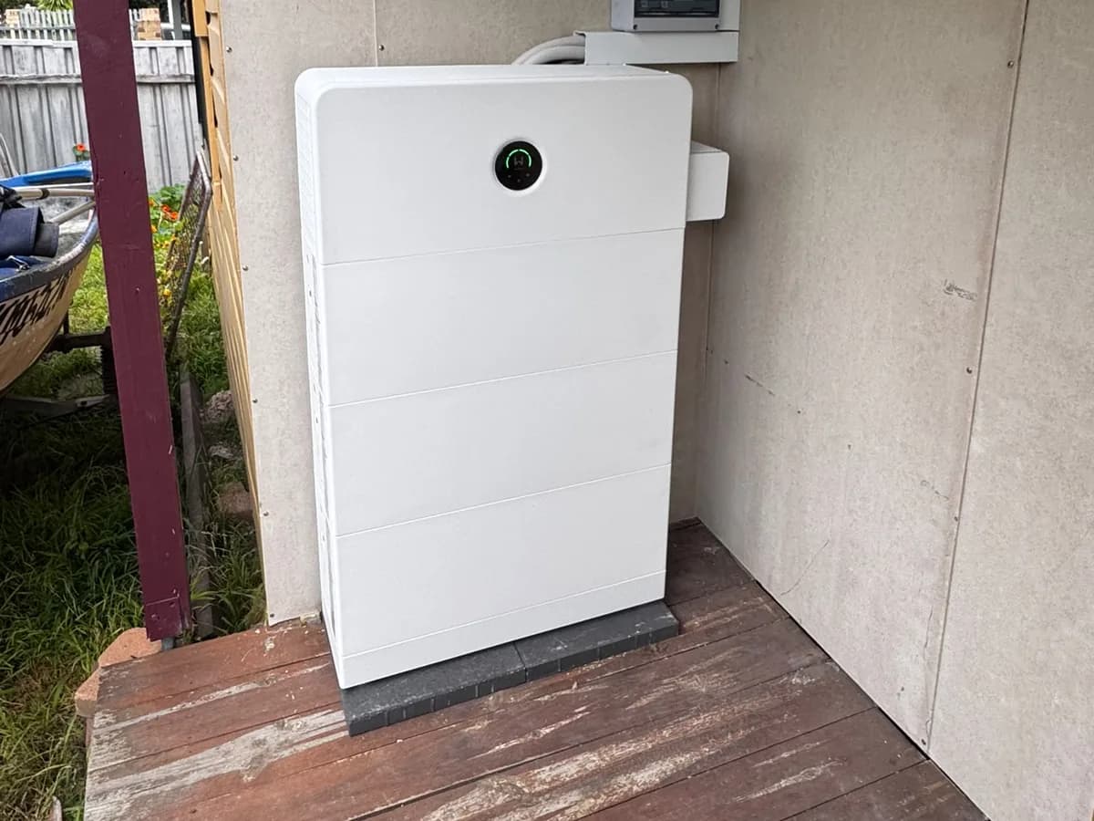 A home battery installed by EFS Solar on a covered deck in Beresfield, beside the switchboard and shutdown signage