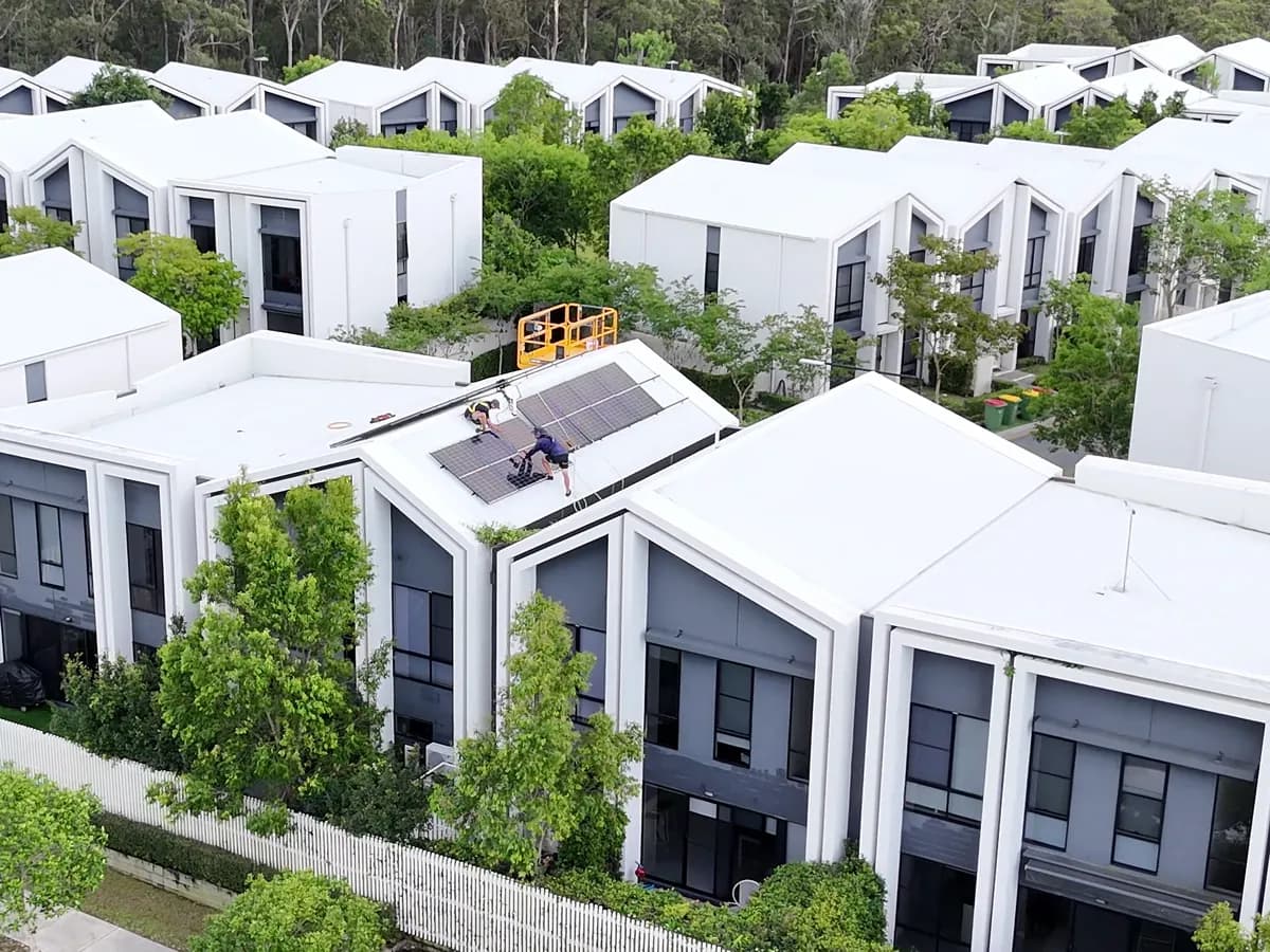 Solar installation in Pimpama — installers fitting solar to a new townhouse roof in a modern estate