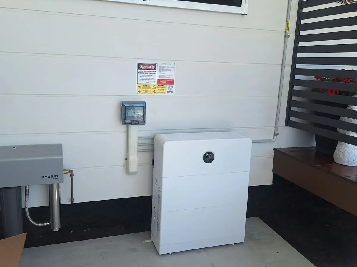 A home battery installed by EFS Solar against a weatherboard wall at a Toogoom home, beside the water filter and isolator